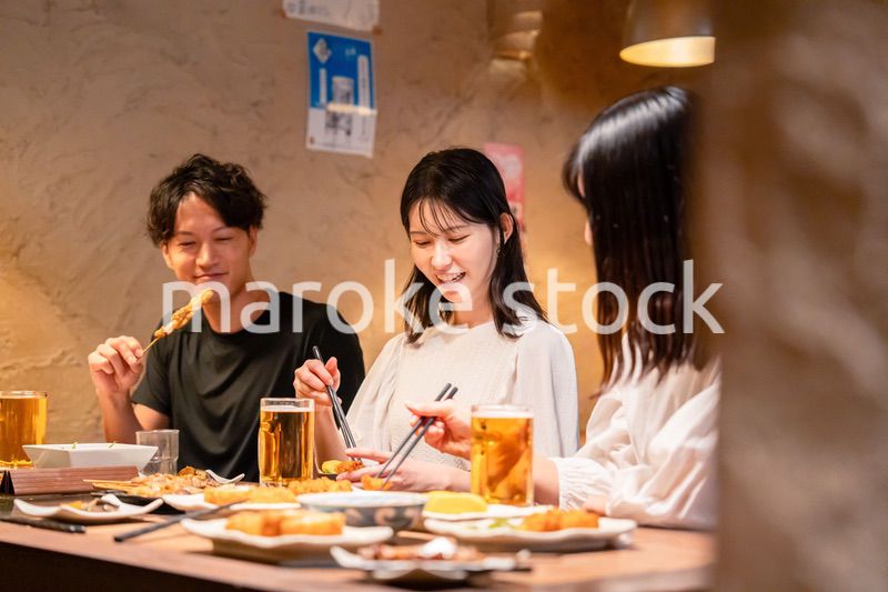 居酒屋でお酒を飲む若い男女