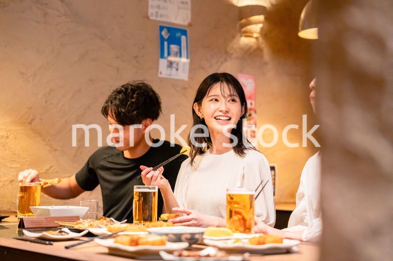 居酒屋でお酒を飲む若い男女