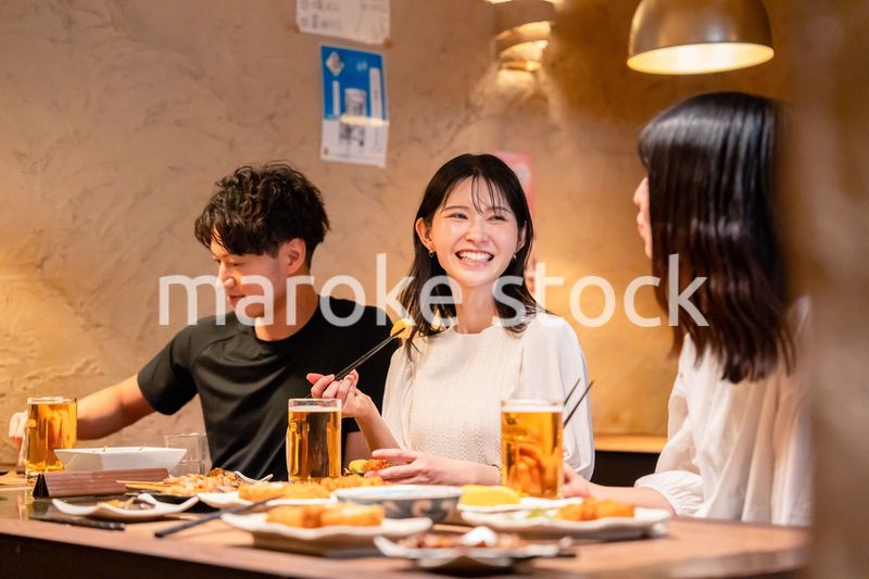 居酒屋でお酒を飲む若い男女