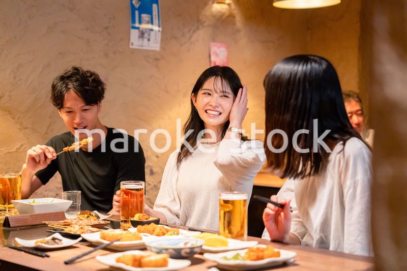 居酒屋でお酒を飲む若い男女