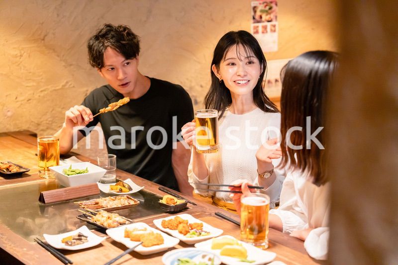 居酒屋でお酒を飲む若い男女