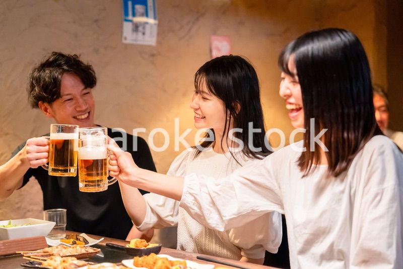 居酒屋でお酒を飲む若い男女