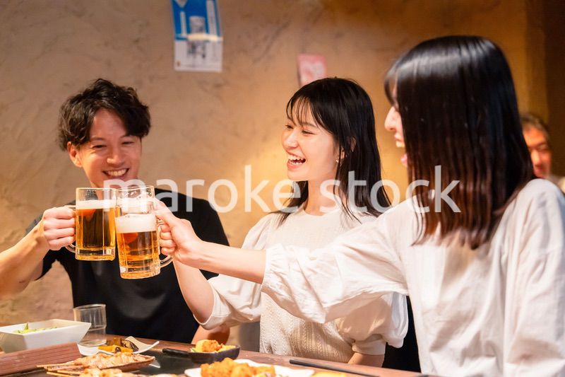 居酒屋でお酒を飲む若い男女