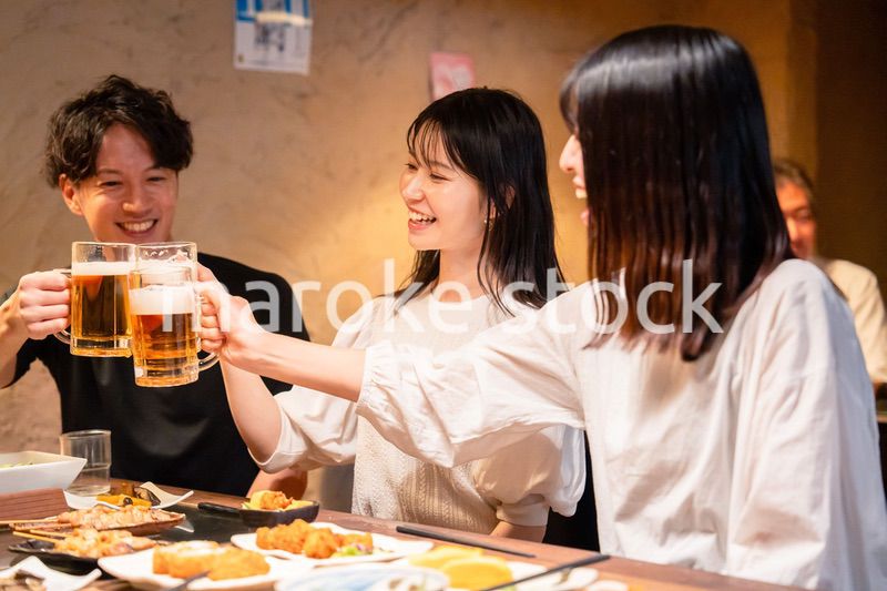 居酒屋でお酒を飲む若い男女