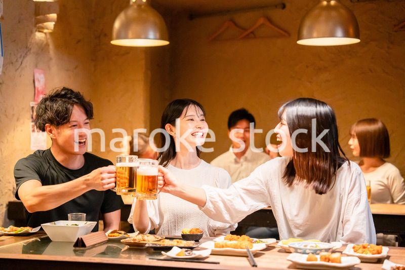 居酒屋でお酒を飲む若い男女