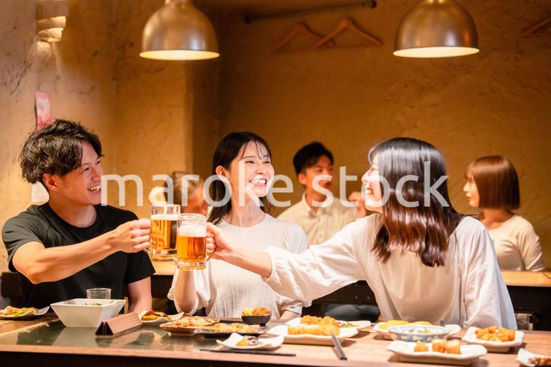 居酒屋でお酒を飲む若い男女