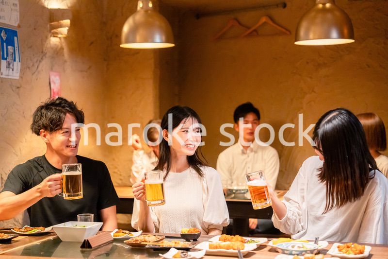 居酒屋でお酒を飲む若い男女