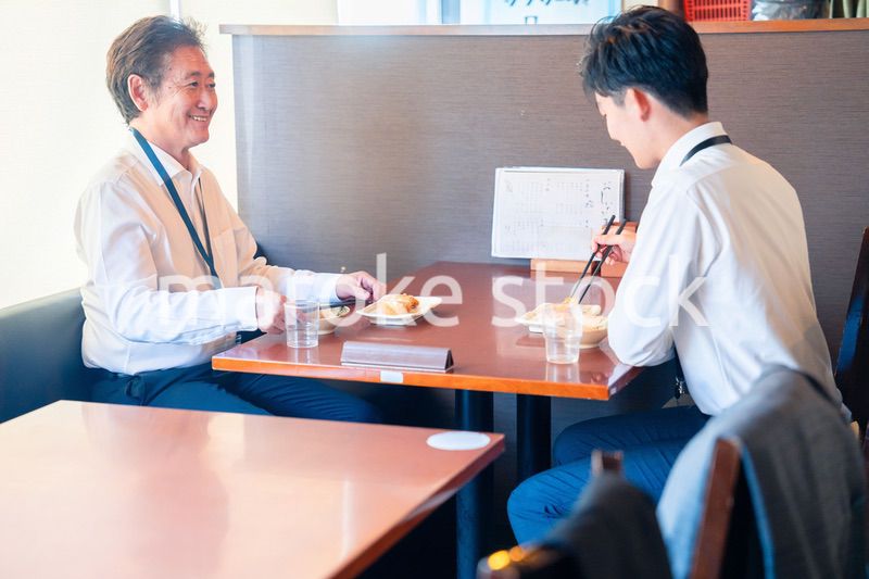 レストランでお昼ごはんを食べる二人のビジネスマン
