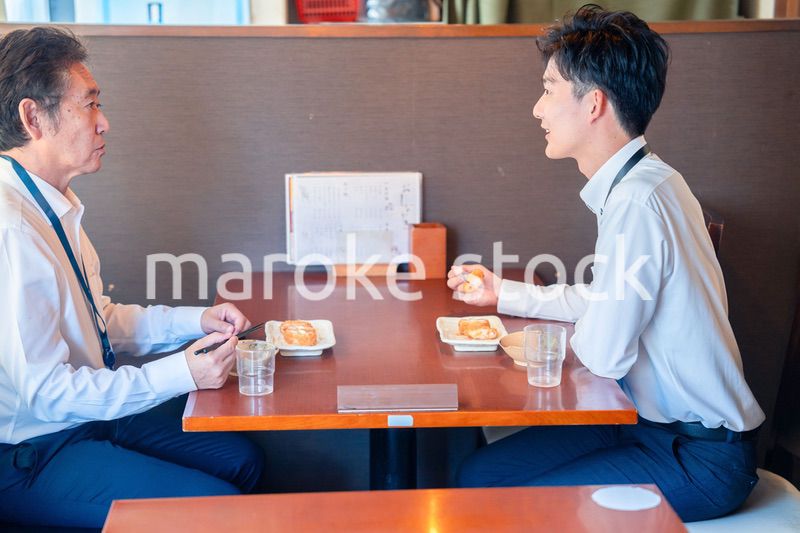 レストランでお昼ごはんを食べる二人のビジネスマン