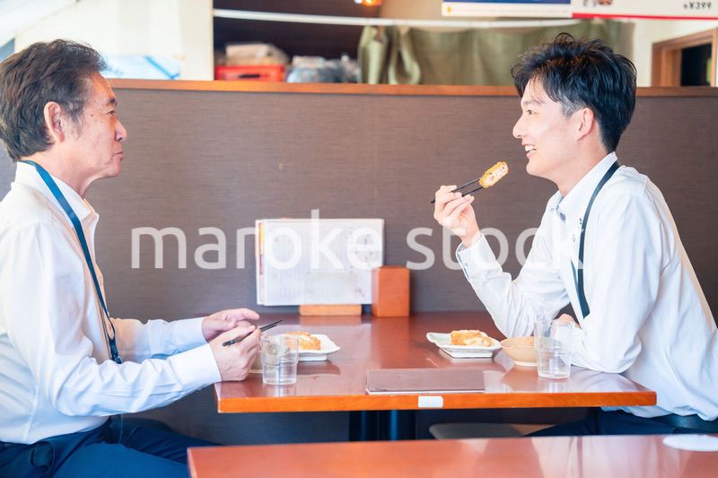 レストランでお昼ごはんを食べる二人のビジネスマン