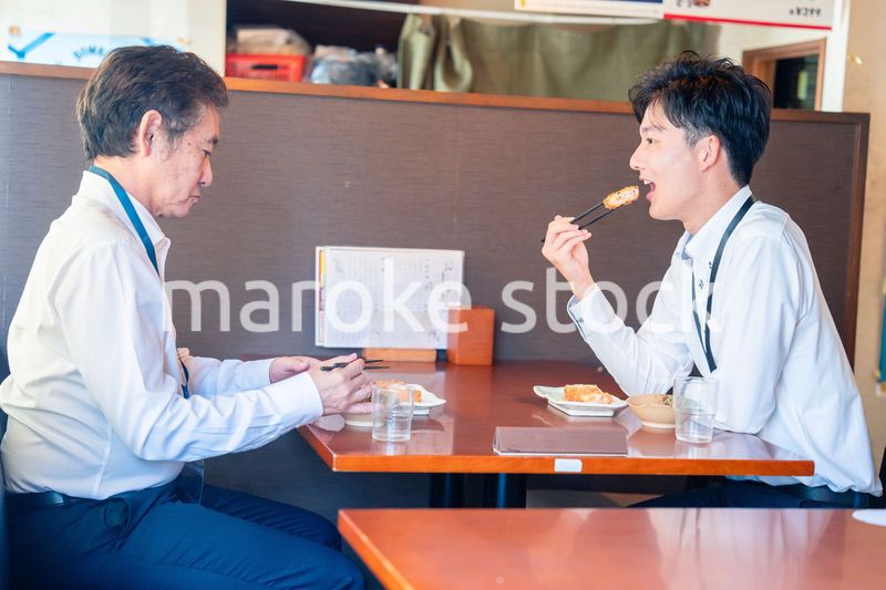レストランでお昼ごはんを食べる二人のビジネスマン