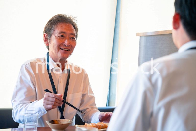 レストランでお昼ごはんを食べる二人のビジネスマン