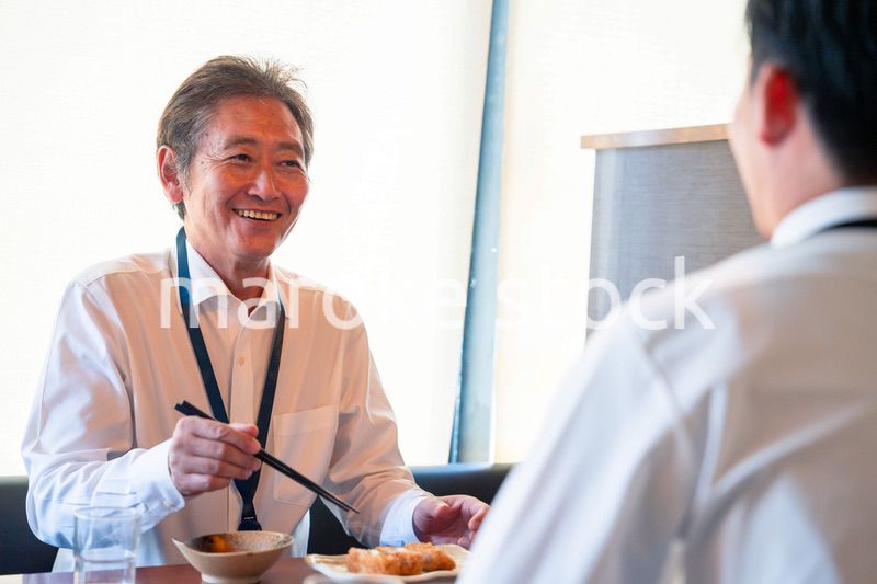 レストランでお昼ごはんを食べる二人のビジネスマン