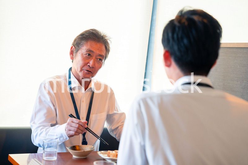 レストランでお昼ごはんを食べる二人のビジネスマン