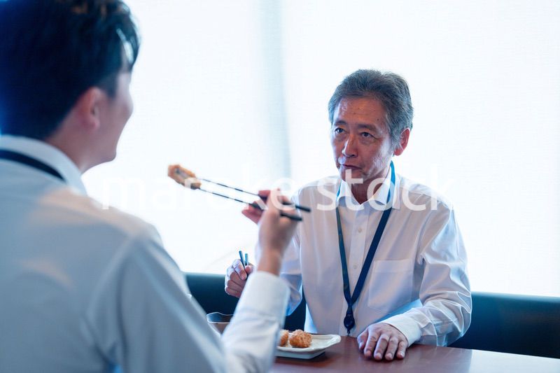 レストランでお昼ごはんを食べる二人のビジネスマン