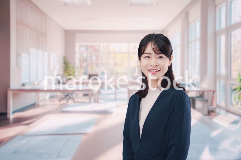 オフィスカジュアルでオフィスに立つ若い女性