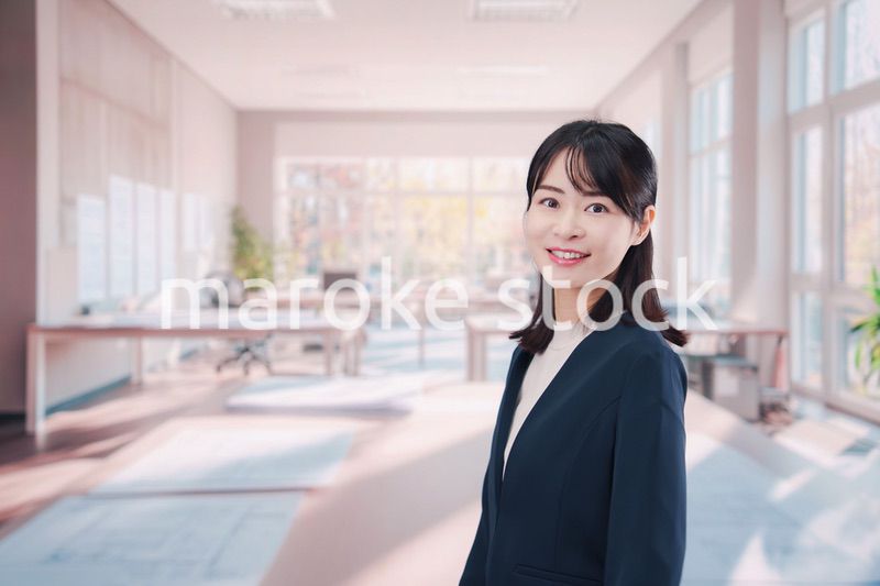 オフィスカジュアルでオフィスに立つ若い女性