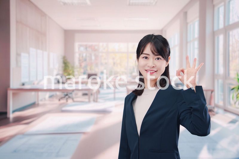 オフィスカジュアルでオフィスに立つ若い女性