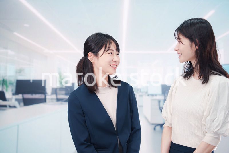 オフィスで会話をする二人のビジネスウーマン