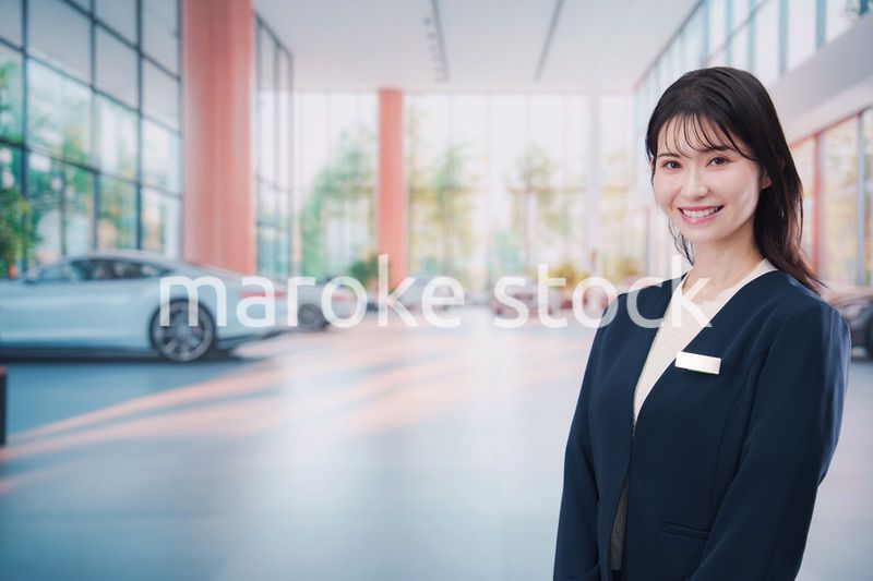 カーディーラーで接客をする若い女性