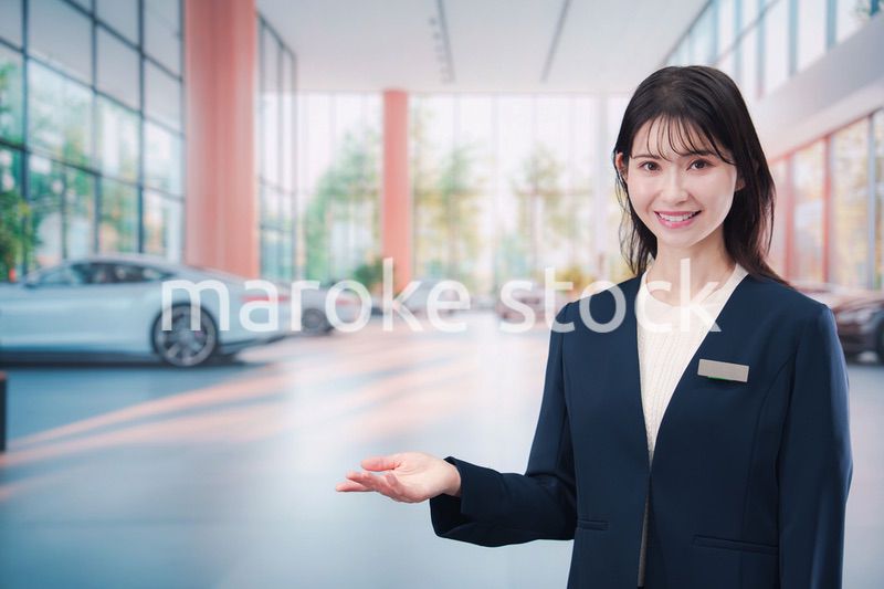 カーディーラーで接客をする若い女性