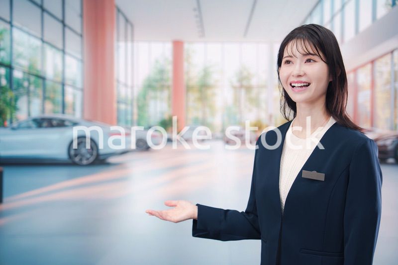 カーディーラーで接客をする若い女性