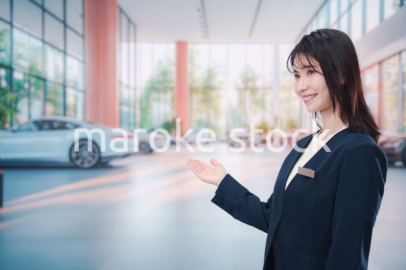 カーディーラーで接客をする若い女性