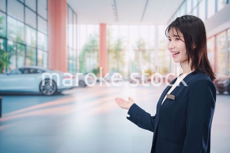 カーディーラーで接客をする若い女性