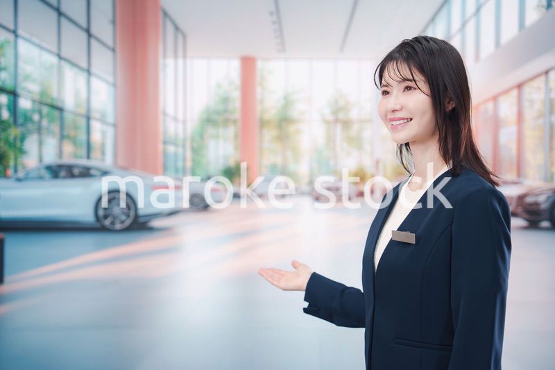 カーディーラーで接客をする若い女性
