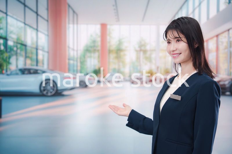 カーディーラーで接客をする若い女性