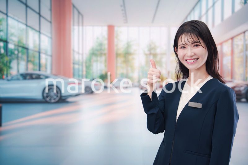 カーディーラーで接客をする若い女性