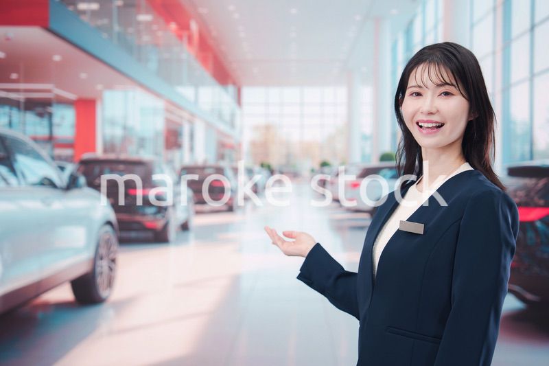 カーディーラーで接客をする若い女性