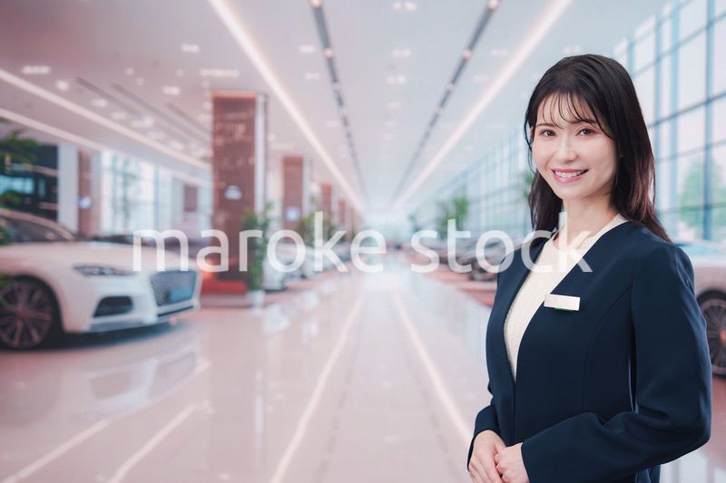 カーディーラーで接客をする若い女性