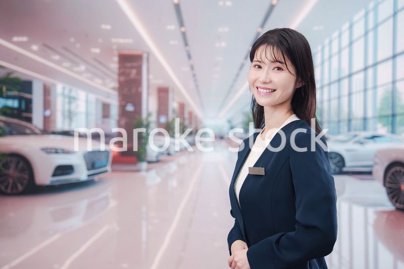 カーディーラーで接客をする若い女性