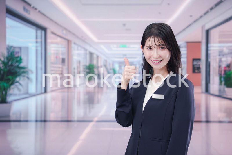ショッピングモールで案内をするスタッフの女性