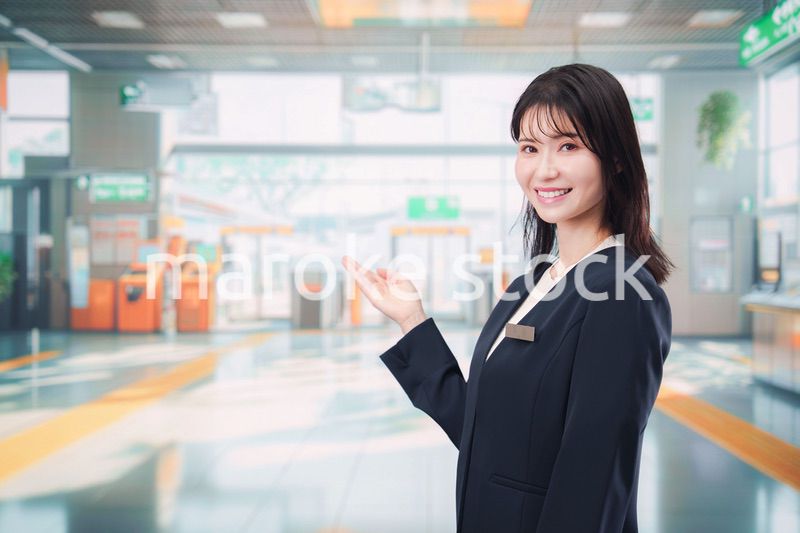 駅で案内をする若い女性のスタッフ