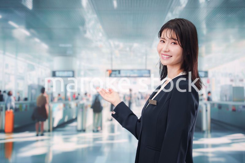 駅で案内をする若い女性のスタッフ