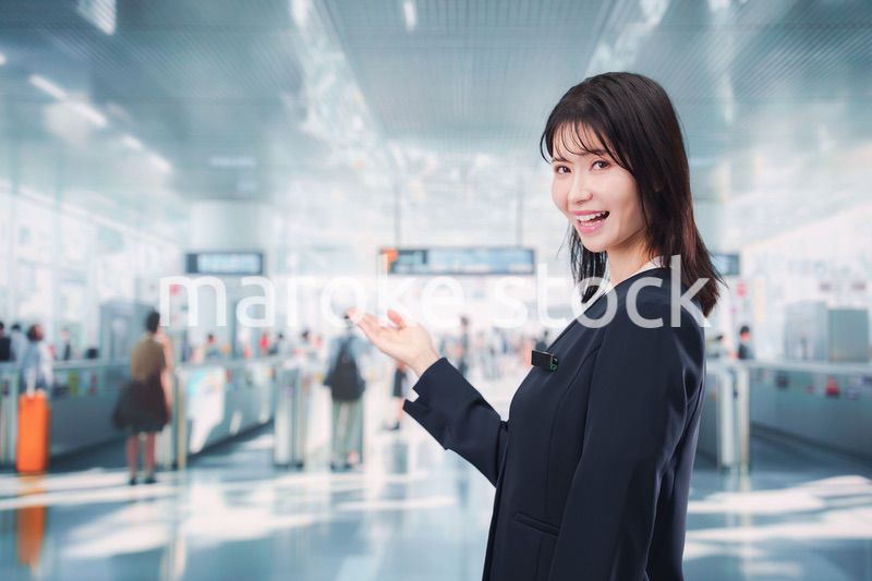 駅で案内をする若い女性のスタッフ