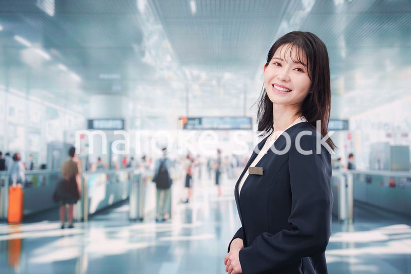 駅で案内をする若い女性のスタッフ