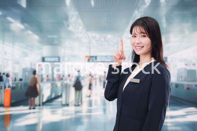 駅で案内をする若い女性のスタッフ