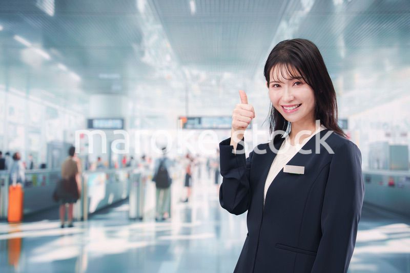 駅で案内をする若い女性のスタッフ