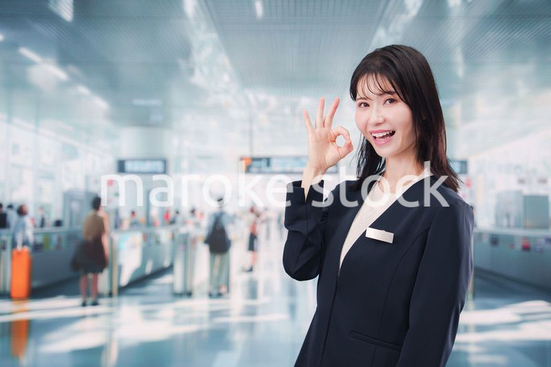 駅で案内をする若い女性のスタッフ