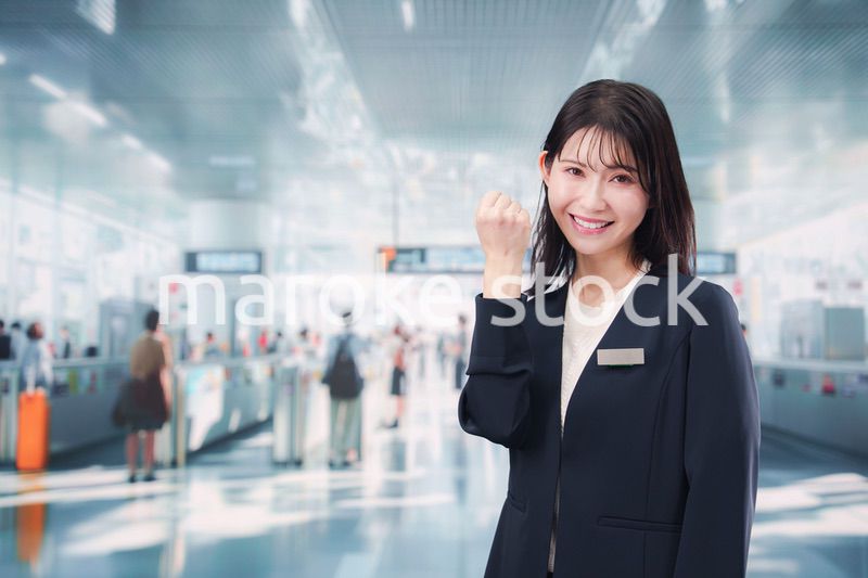 駅で案内をする若い女性のスタッフ