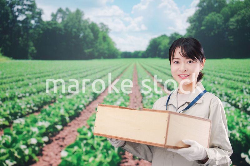 広い農園で働く農家の若い女性
