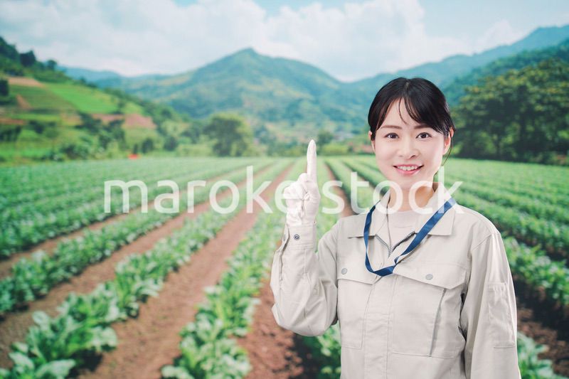 広い農園で働く農家の若い女性