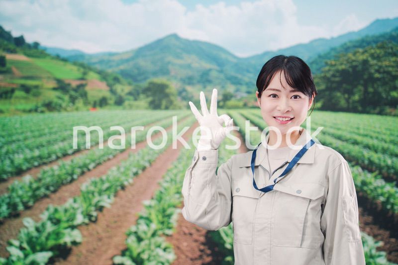 広い農園で働く農家の若い女性