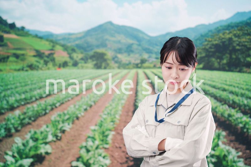 畑で悩む農家の若い女性