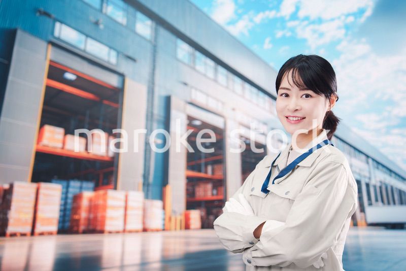 物流拠点で働く作業服姿の若い女性