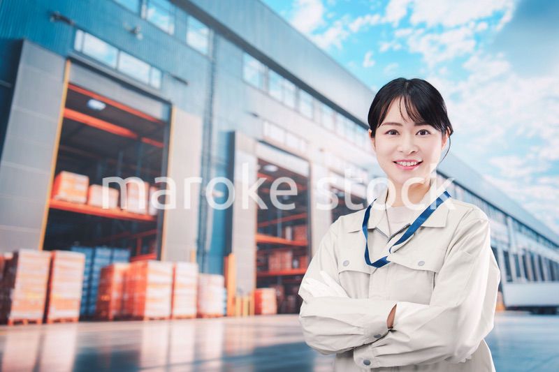 物流拠点で働く作業服姿の若い女性