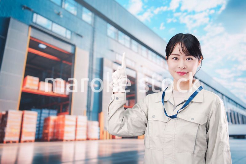 物流拠点で働く作業服姿の若い女性
